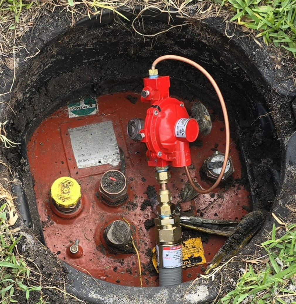 Propane Gas Dome Cleaning Maintenance A certified gas installer repairs a propane tank and cleans its dome cover, ensuring professional propane tank repair. The photo highlights expert gas leak detection and precise propane system repairs using high quality, gas-rated materials.