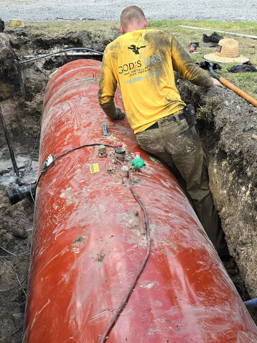 God's Gas Line Leak Repair Services A professional gas line repair technician in a branded uniform works diligently to fix a natural gas line leak in a residential backyard. The image showcases advanced tools and safety equipment, emphasizing expertise in propane tank repair and natural gas